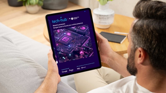 Man holding a tablet displaying the Tech Hub retail business guide with circuit board graphics